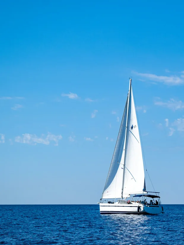 Catamaran under sail on open blue water